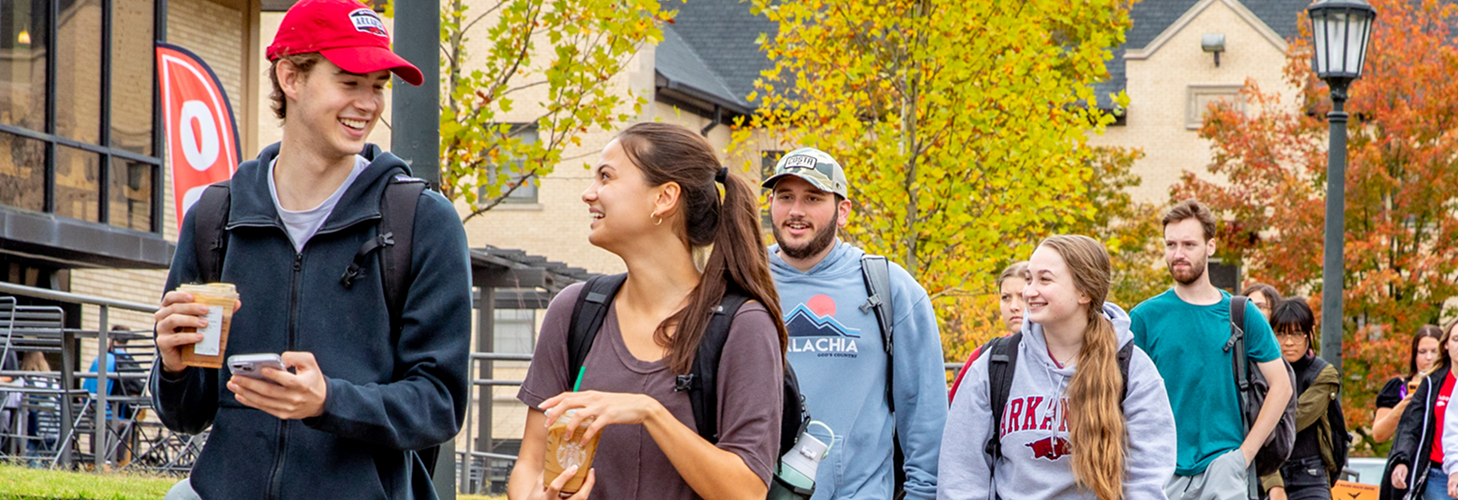 Smiling successful students walking together on campus